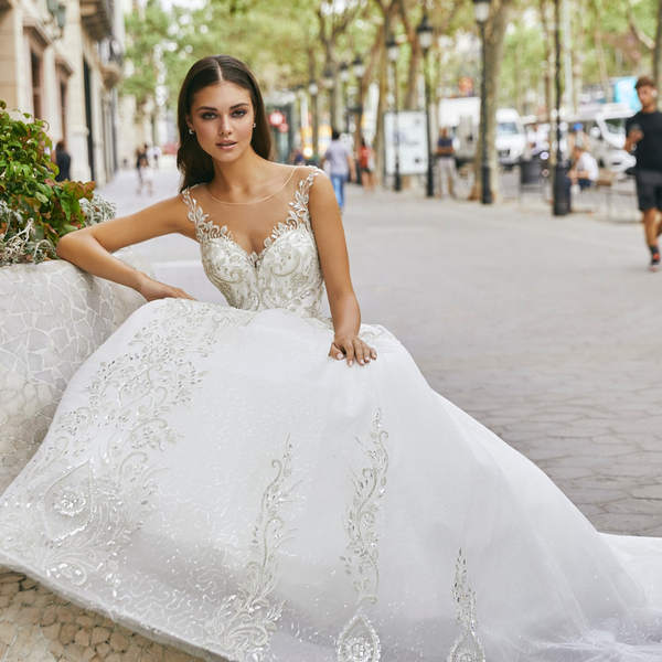 Model wearing Ronald Joyce style 69720, a beautiful ballgown wedding dress with a sweetheart neckline and illusion strap detail 